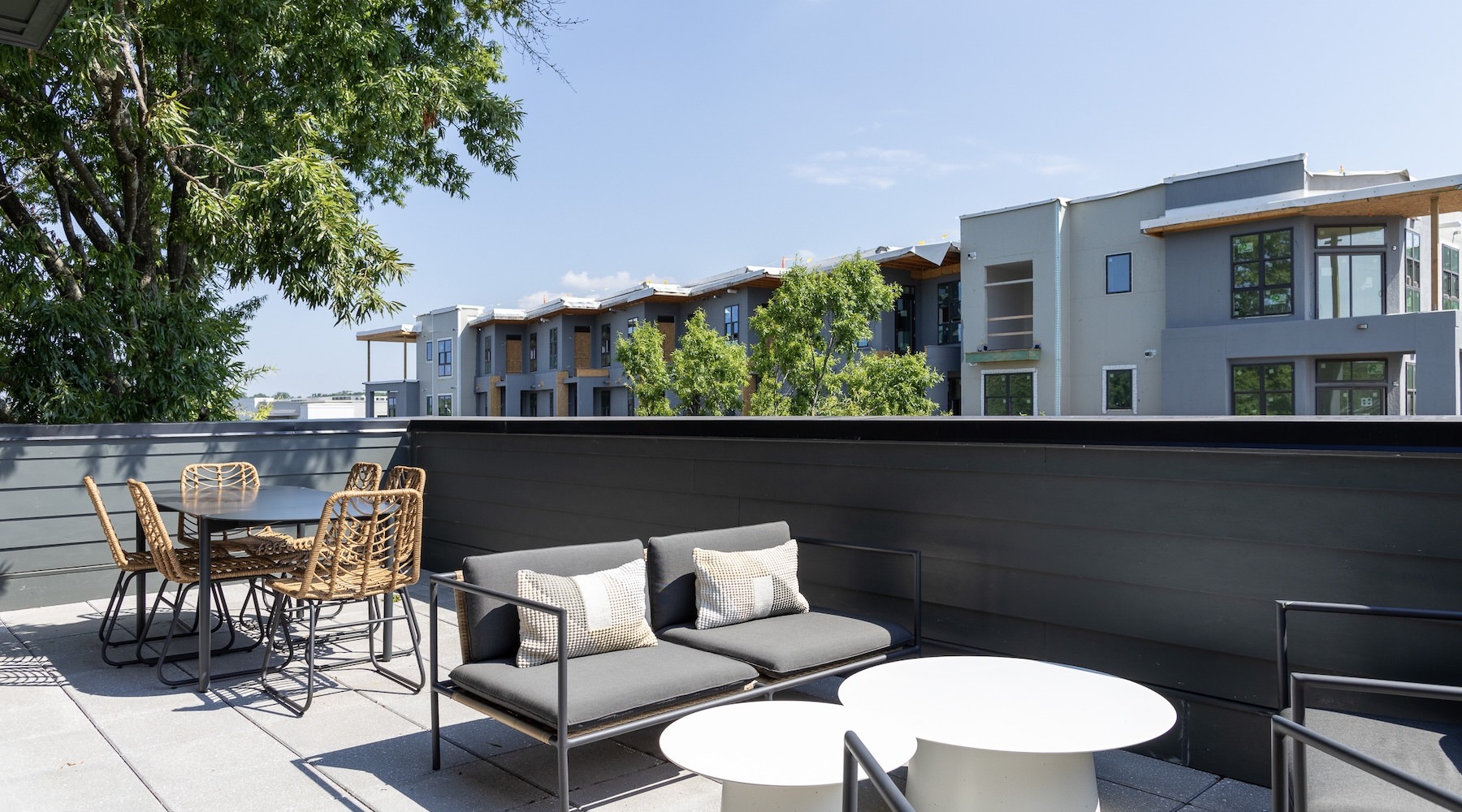 a rooftop lounge area with chairs and tables