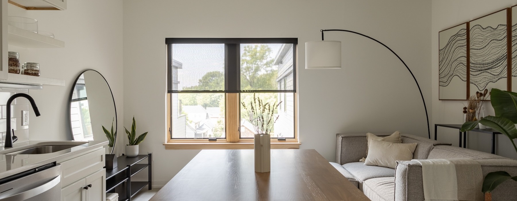 a kitchen island with chairs and a living room beyond