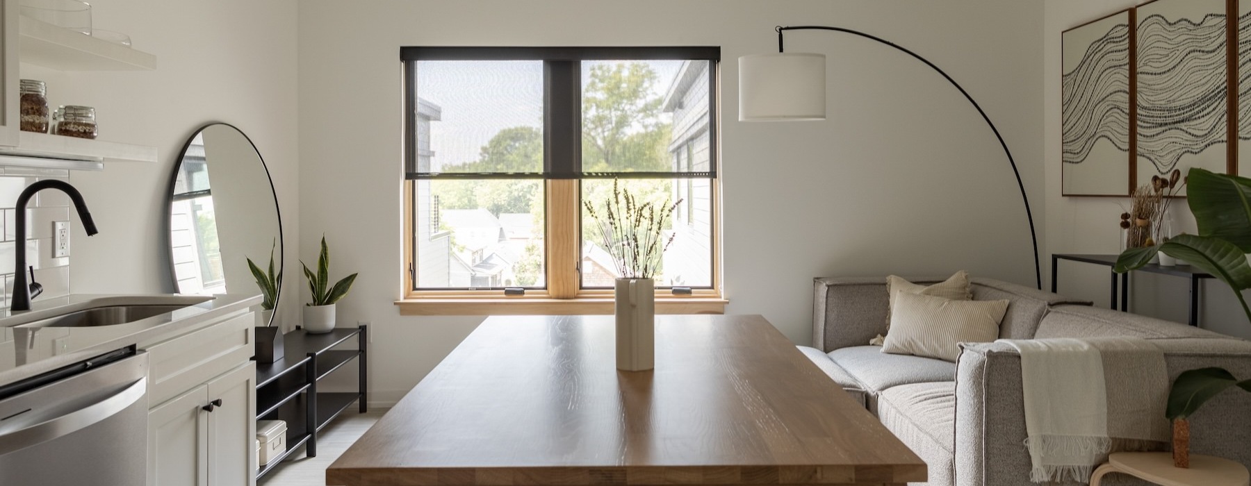 a kitchen island with chairs and a living room beyond