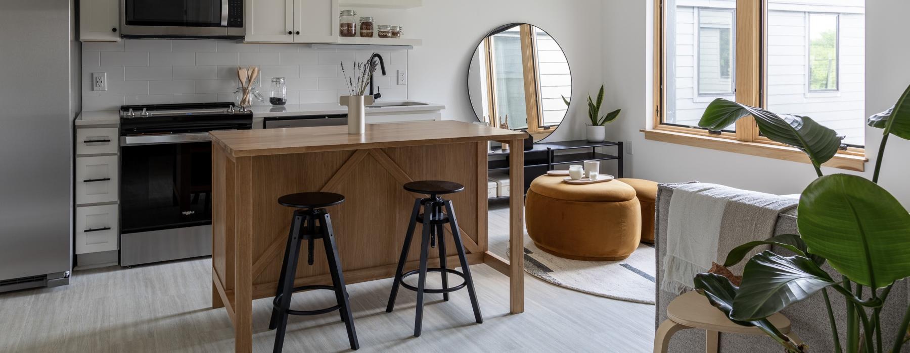 a kitchen with white cabinets and an island with barstools