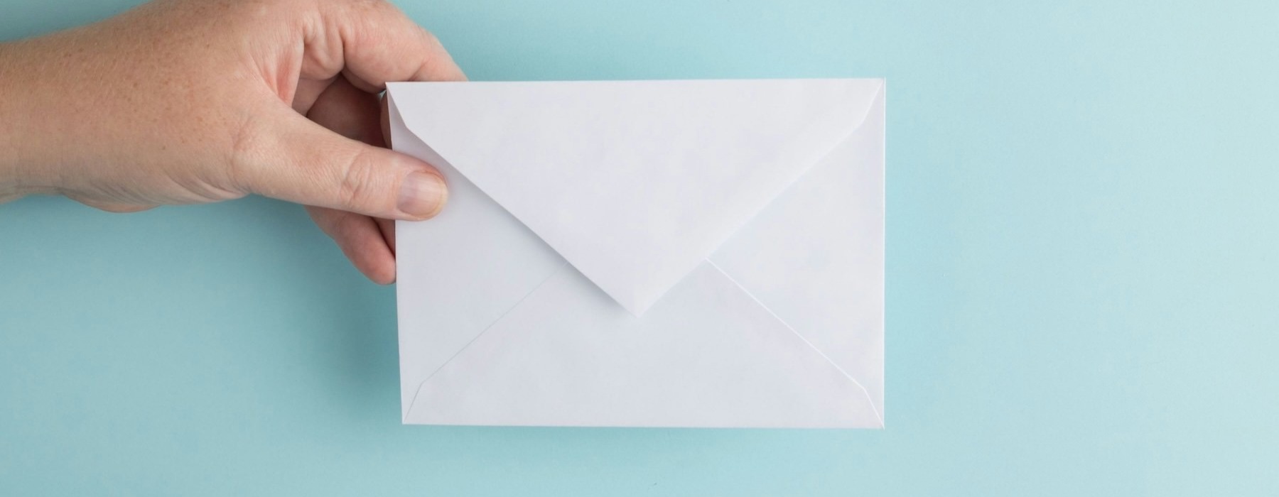 a hand holding an envelope